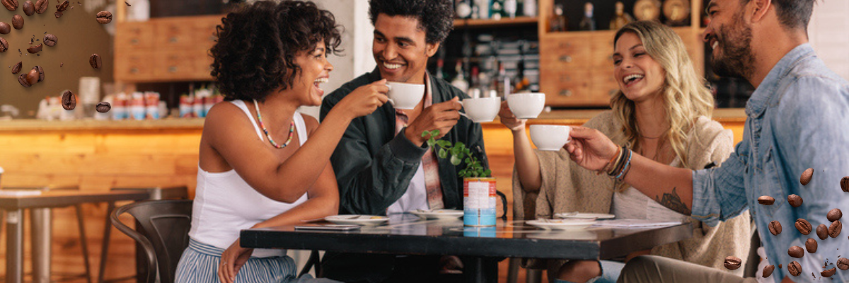 Group of friends in a cafe enjoying and cheering with cups of coffee.